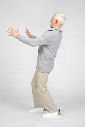 Side view of a man standing and reaching out arms