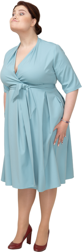 Vista frontale di una donna in abito blu che fa le smorfie