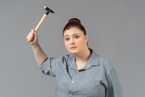 Young woman threatening with a hammer