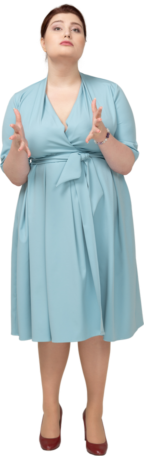 一个穿着蓝色裙子的女人的前视图打手势