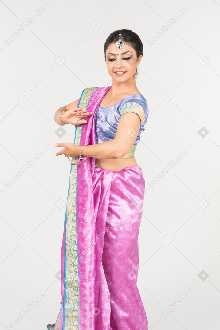 Young indian woman in purple sari dancing