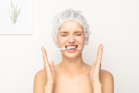 Mujer sosteniendo jeringa con sus dientes
