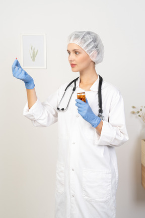 Three-quarter view of a young female doctor offering a pill