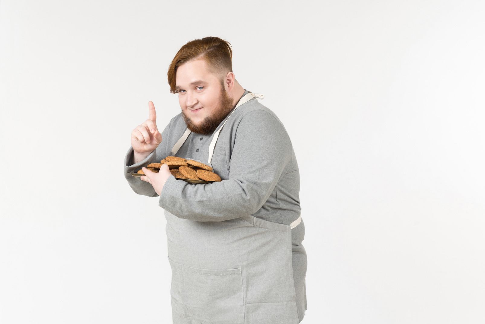 Looking cunning fat man with plate of cookies