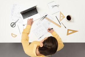 A female architect working on architectural drawings