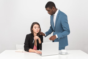 Homem explicando algumas coisas de trabalho para o colega do sexo feminino