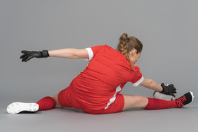 Uma jogador de futebol feminino que se estende antes da partida