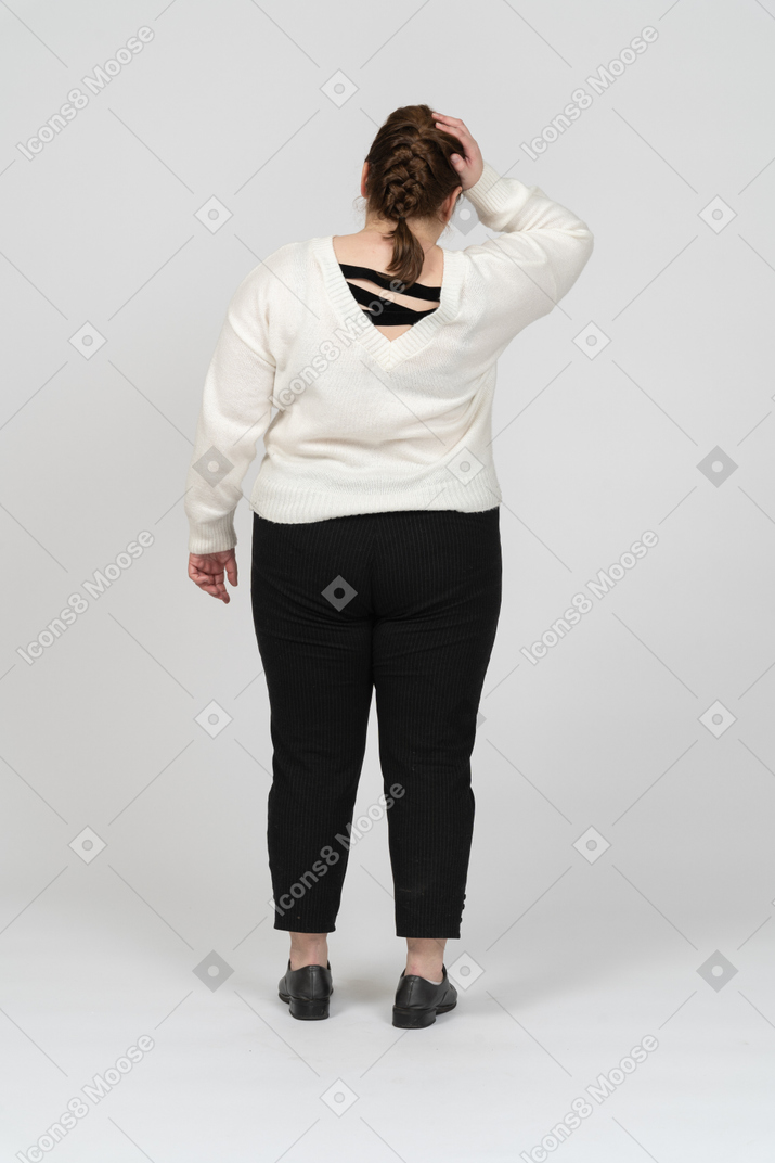Plump woman in casual clothes touching her head