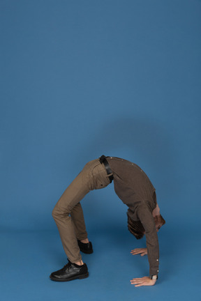 Slim young man doing gymnastic exercises