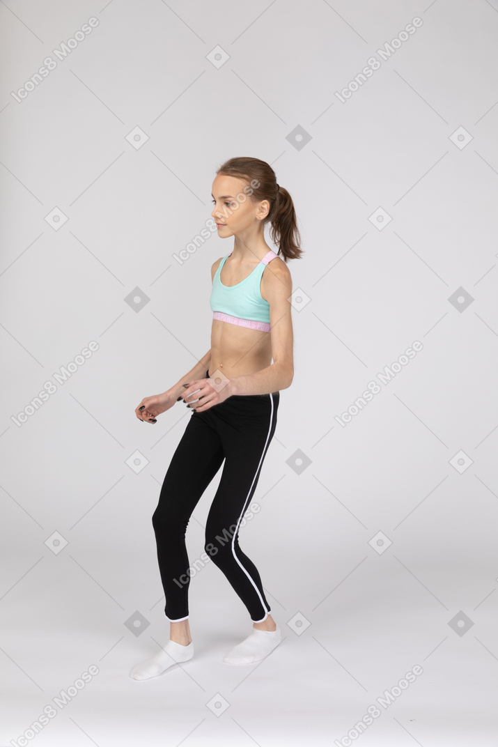 スポーツウェアを歩いている10代の少女の4分の3のビュー