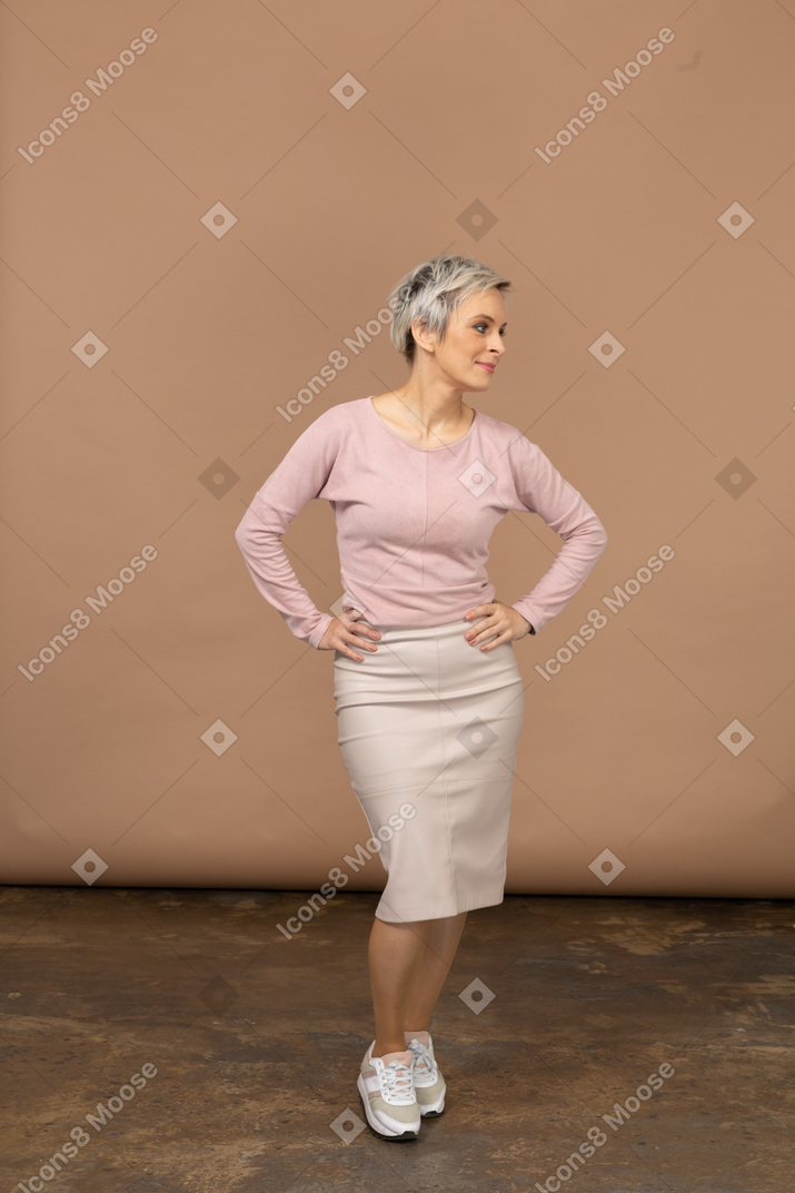 Vue de face d'une femme en vêtements décontractés posant avec les mains sur les hanches