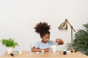 Good looking cute girl doing science at the table