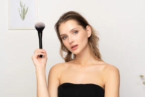 Vista frontal, de, un, sensual, mujer joven, tenencia, un, cepillo de maquillaje