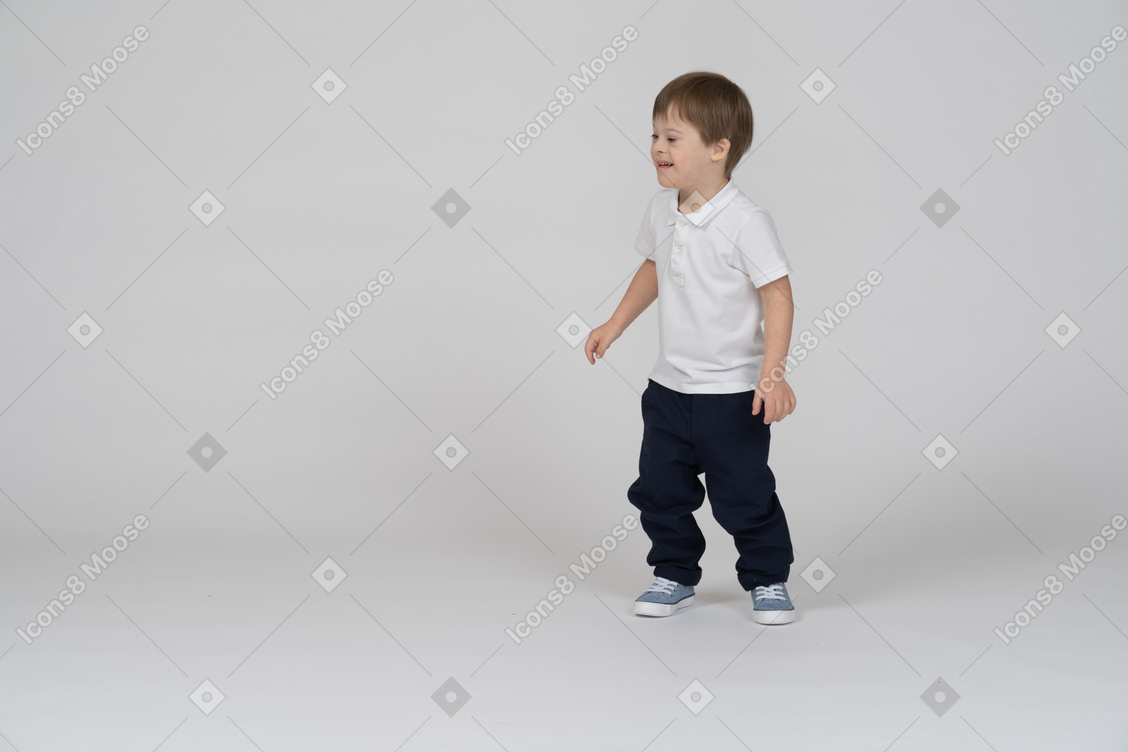 Vista de três quartos de um menino de pé e sorrindo