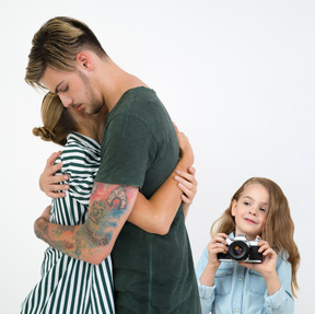 Little girl taking photos of her parents