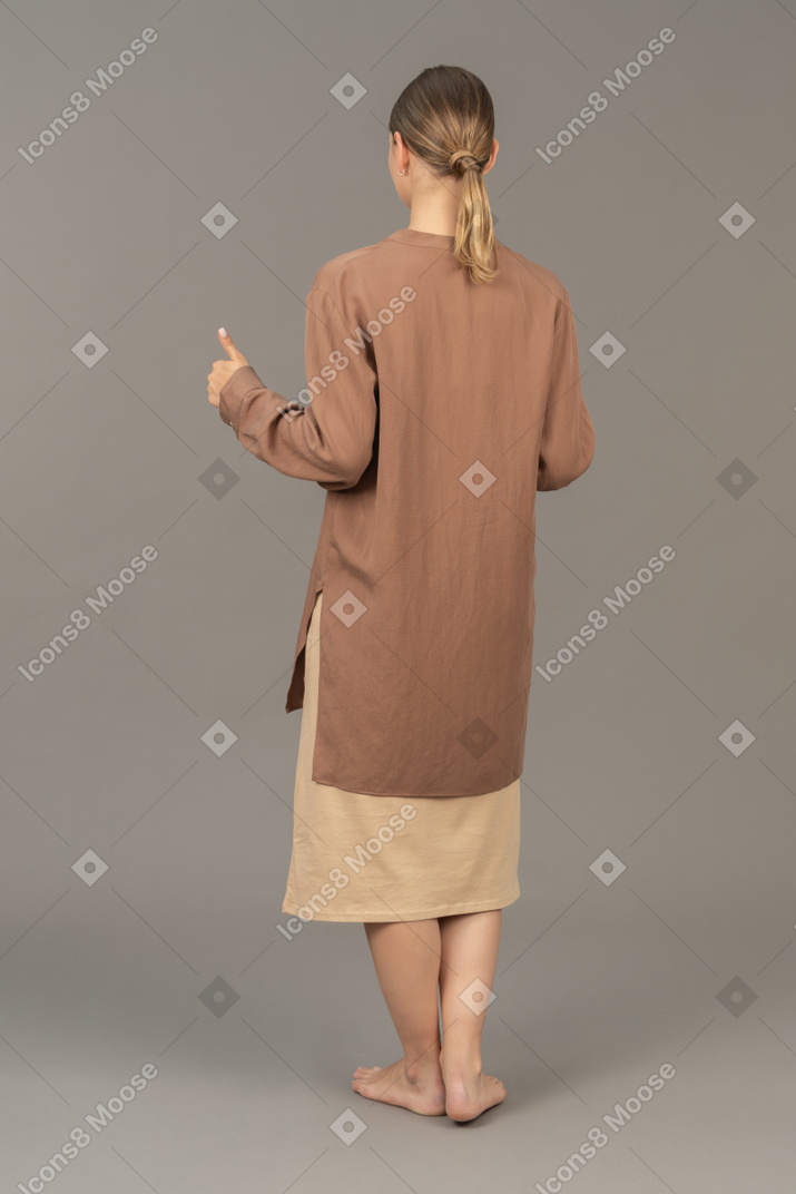 Three-quarter back view of a woman with thumbs up