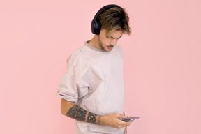 Young man in headphones holding smartphone