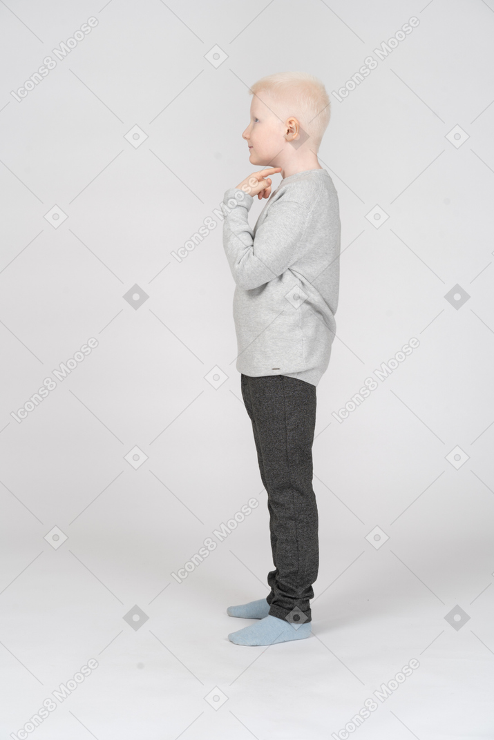 Side view of a little boy touching his neck