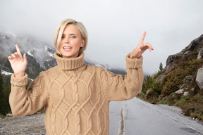 A woman standing on a road with her hands in the air