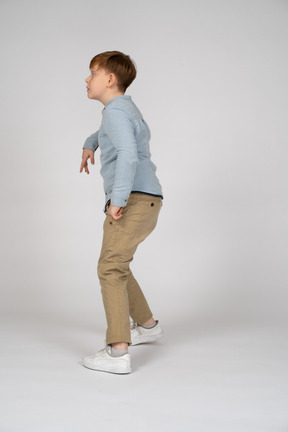 Side view of a little boy doing a pose