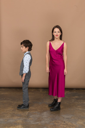 Young woman looking at camera while boy standing near her