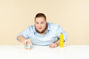 Focused young overweight man cleaning the surface