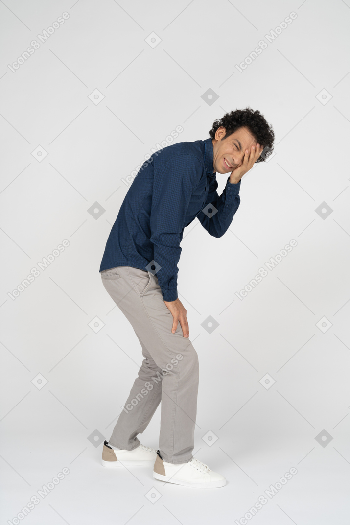 Seitenansicht eines mannes in freizeitkleidung, der ein auge mit der hand bedeckt