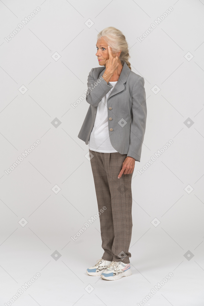 Vista laterale di una vecchia donna in tuta che tocca la fronte