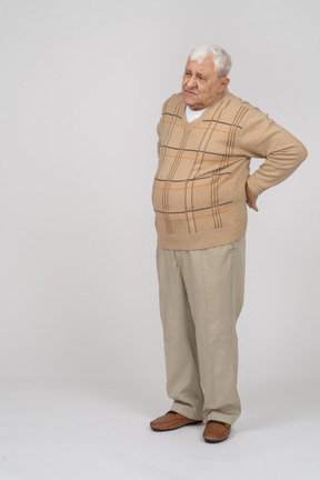 Front view of an old man suffering from back pain