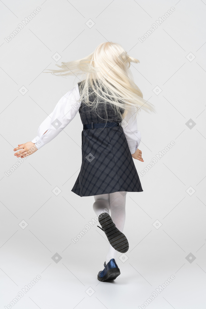 Back view of a schoolgirl spinning around
