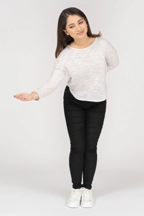 Vista frontal de una educada joven mujer india vistiendo ropa casual ofreciendo algo