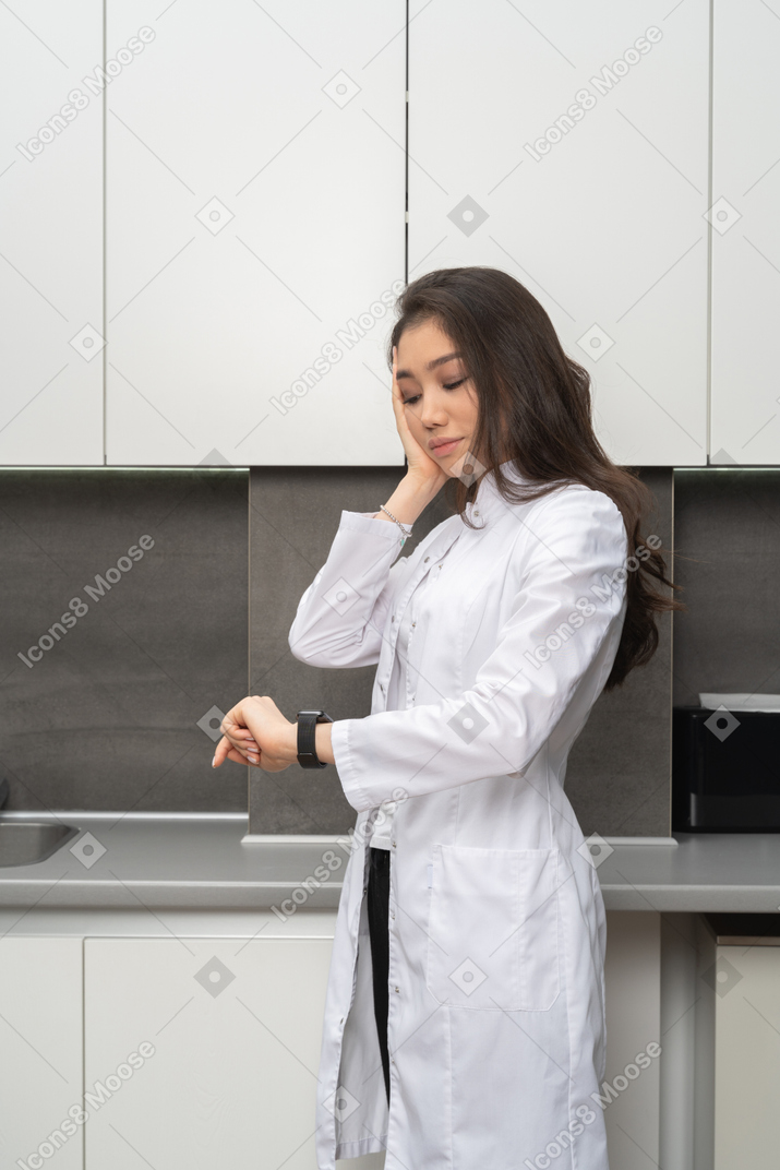 Tired doctor checking the time