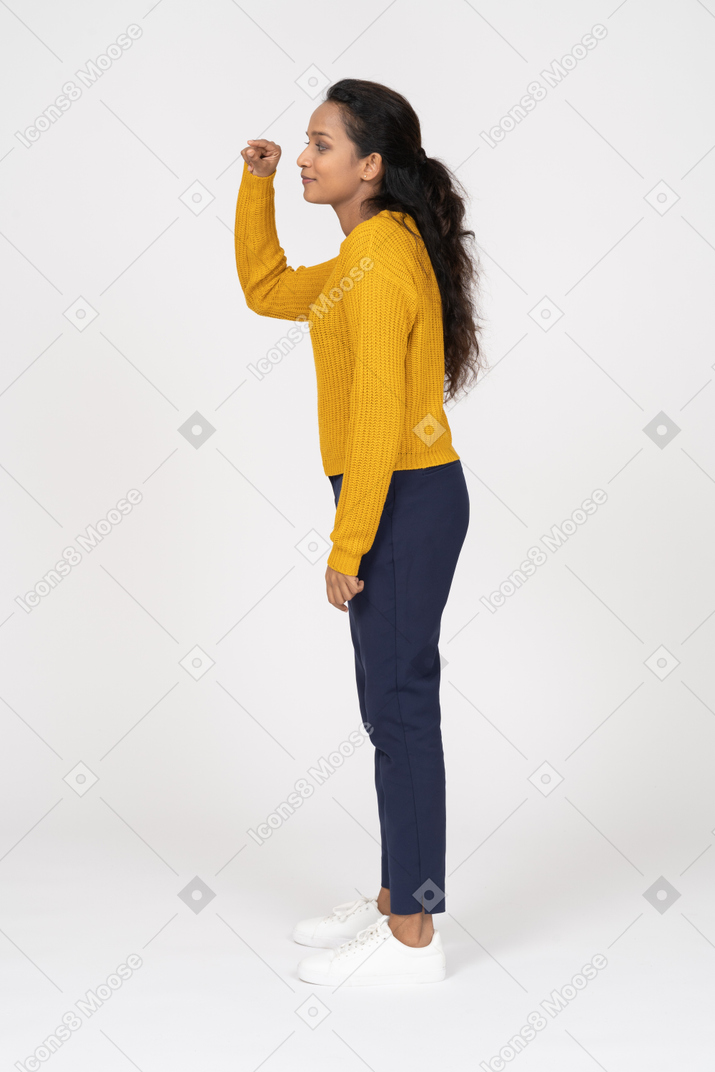 Vista lateral de uma garota com roupas casuais mostrando um tamanho pequeno de algo
