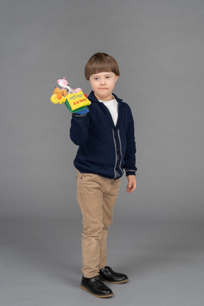 Niño pequeño que parece gruñón mientras sostiene un juguete