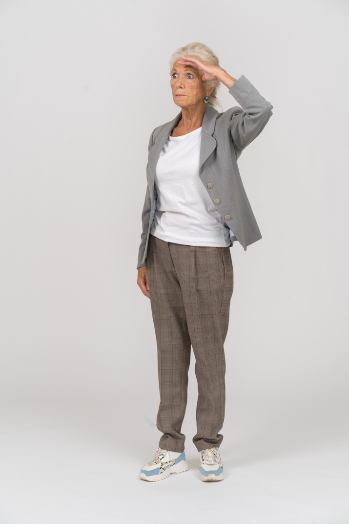 Front view of an old lady in suit saluting with hand