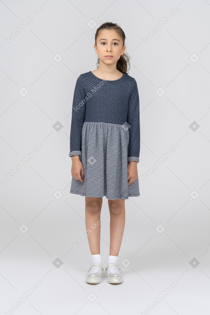 Vista frontal de una niña de pie con los brazos a los lados