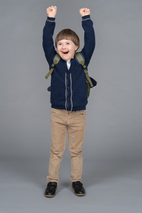 Portrait of a little boy raising his arms in excitement