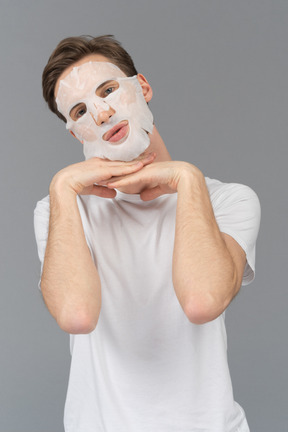 Front view of a young man posing in facial mask