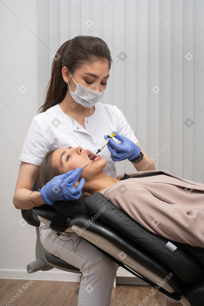 A woman getting her teeth checked by a dentist