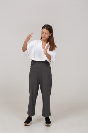 Vista frontale di una giovane donna in abiti da ufficio che mostra una taglia di qualcosa