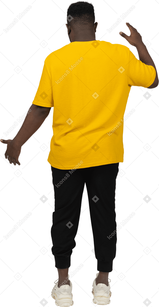 Vista traseira de um jovem de pele escura em uma camiseta amarela mostrando o tamanho de algo