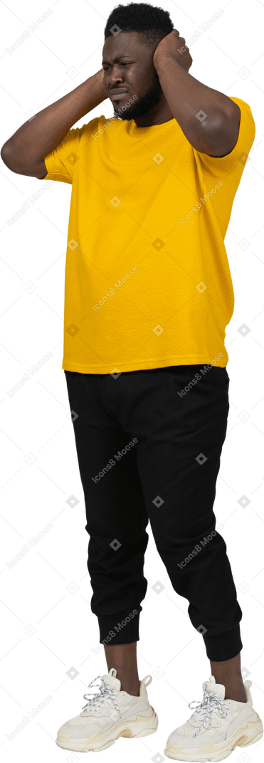 귀를 막고 있는 노란색 티셔츠를 입은 어두운 피부의 남자의 4분의 3 보기