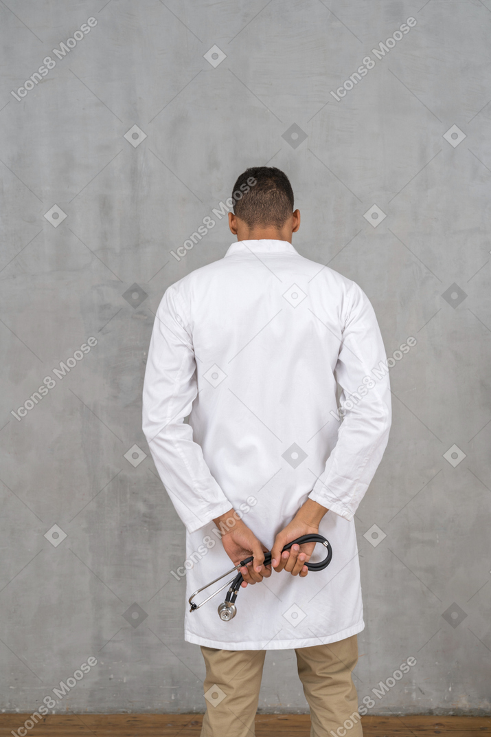Vista traseira de um médico segurando um estetoscópio
