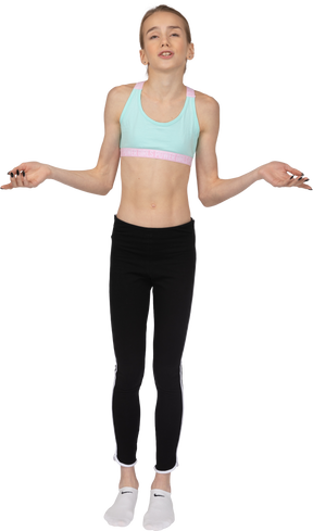 Front view of a teen girl in sportswear raising hands and reasoning