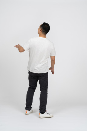 Hombre con ropa informal parado de espaldas a la cámara y mirando hacia arriba
