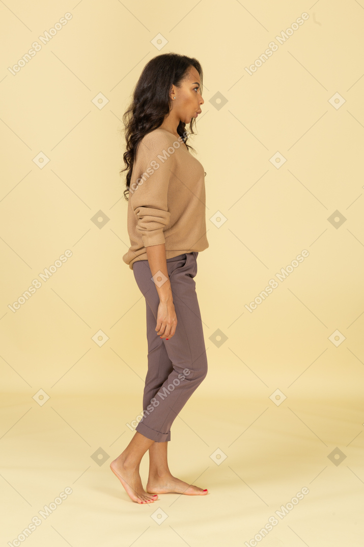 Side view of a surprised grimacing young female in casual clothes