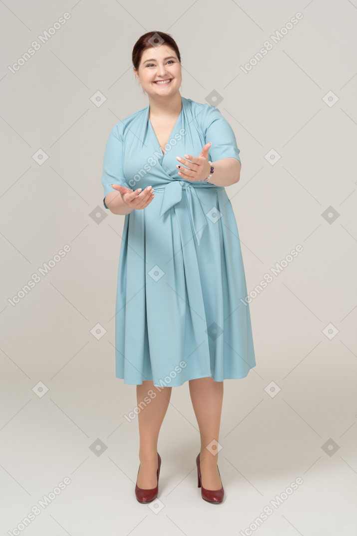 Front view of a woman in blue dress greeting someone