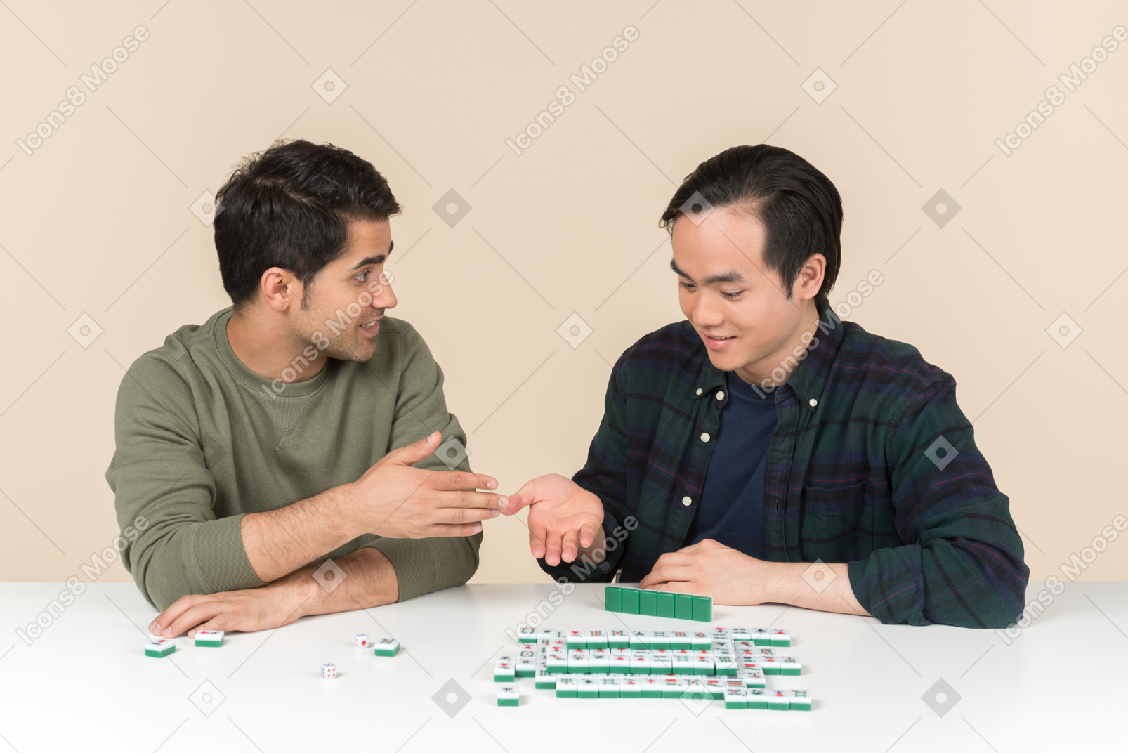 테이블에 앉아 스크램블 게임을하는 젊은 인종 간 친구