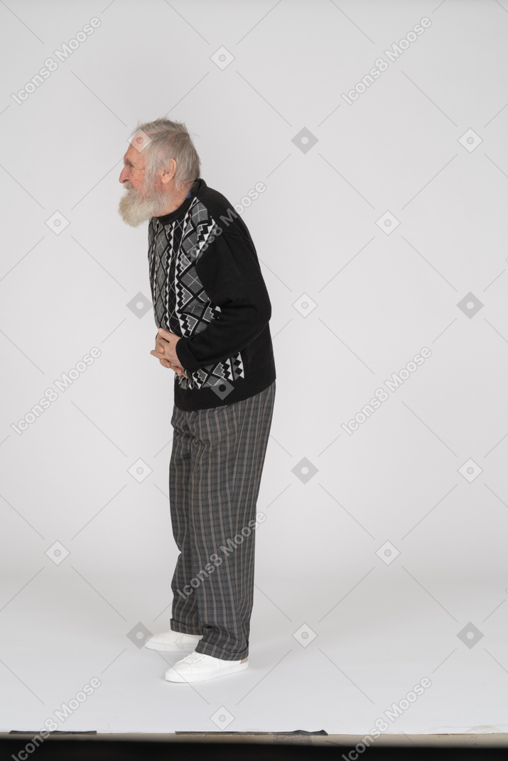 Side view of old man suffering from stomachache