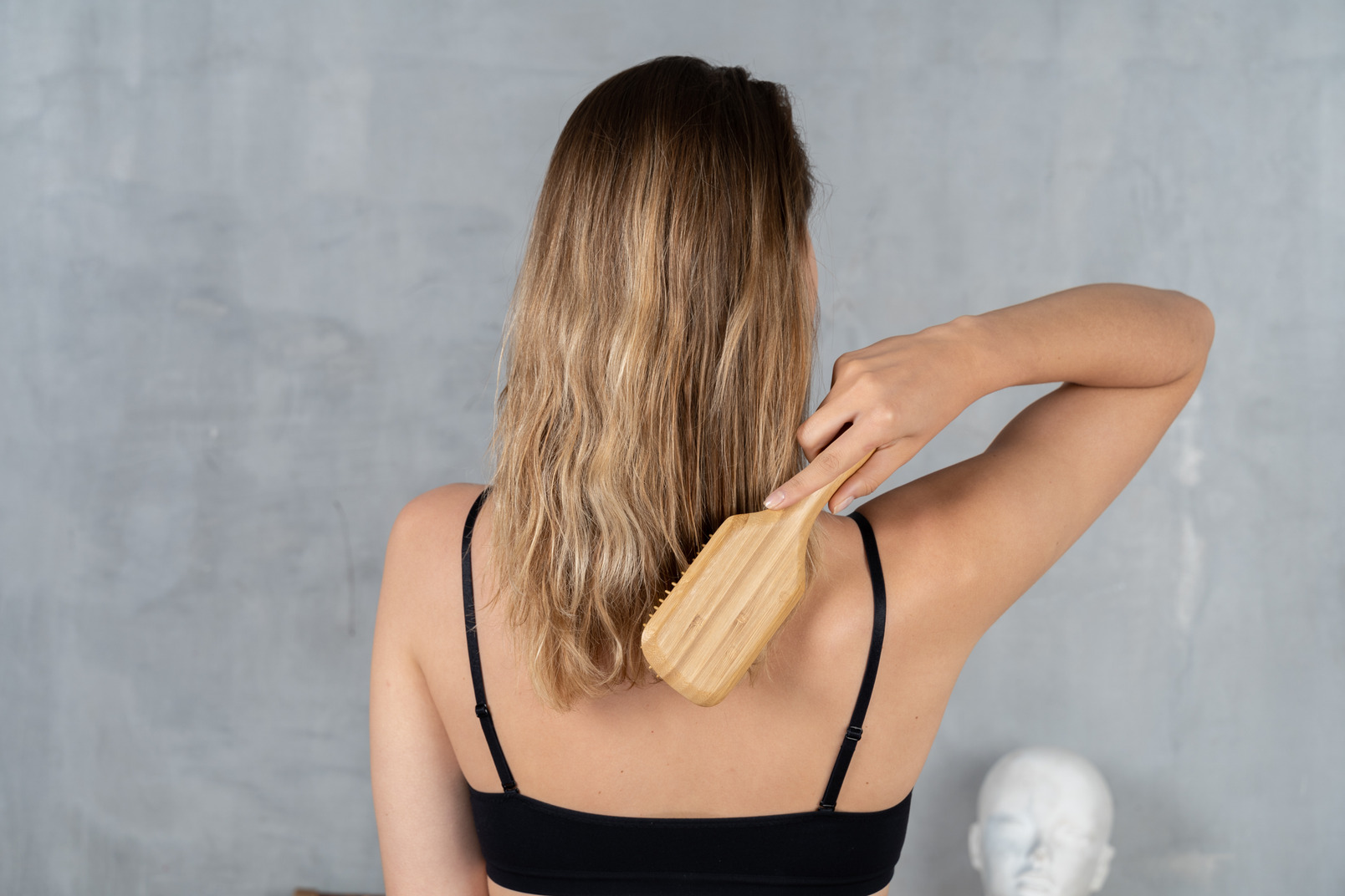 Back view of a young woman brushing her hair